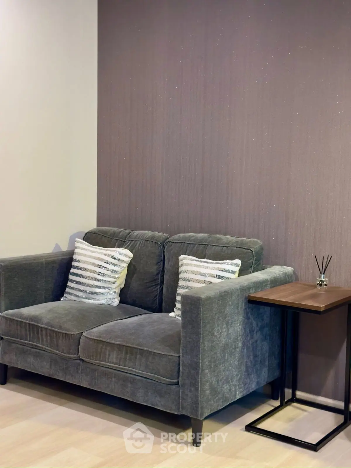 Cozy living room with plush gray sofa and stylish side table, perfect for relaxation.