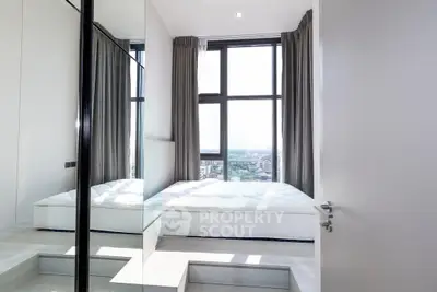 Modern bedroom with large windows and city view, featuring minimalist design and ample natural light.