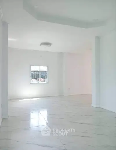 Spacious and bright living room with elegant marble flooring and natural light.
