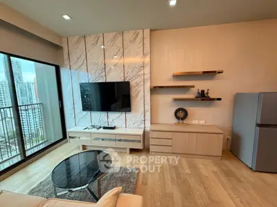 Modern living room with city view, featuring sleek TV setup and stylish decor.