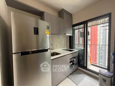 Modern kitchen with sleek appliances and balcony view in urban apartment
