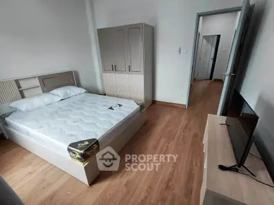 Spacious bedroom with modern furnishings and wooden flooring