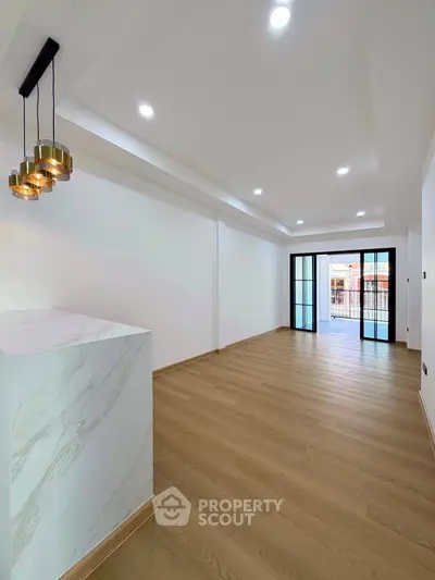 Spacious modern living room with elegant lighting and wooden flooring