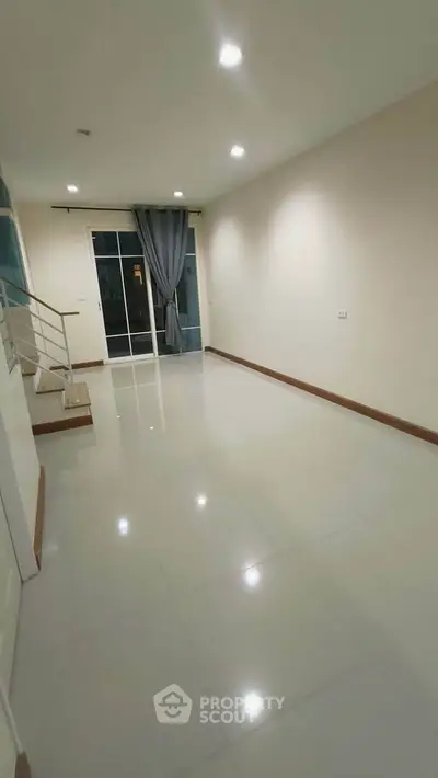 Spacious modern living room with large windows and elegant curtains