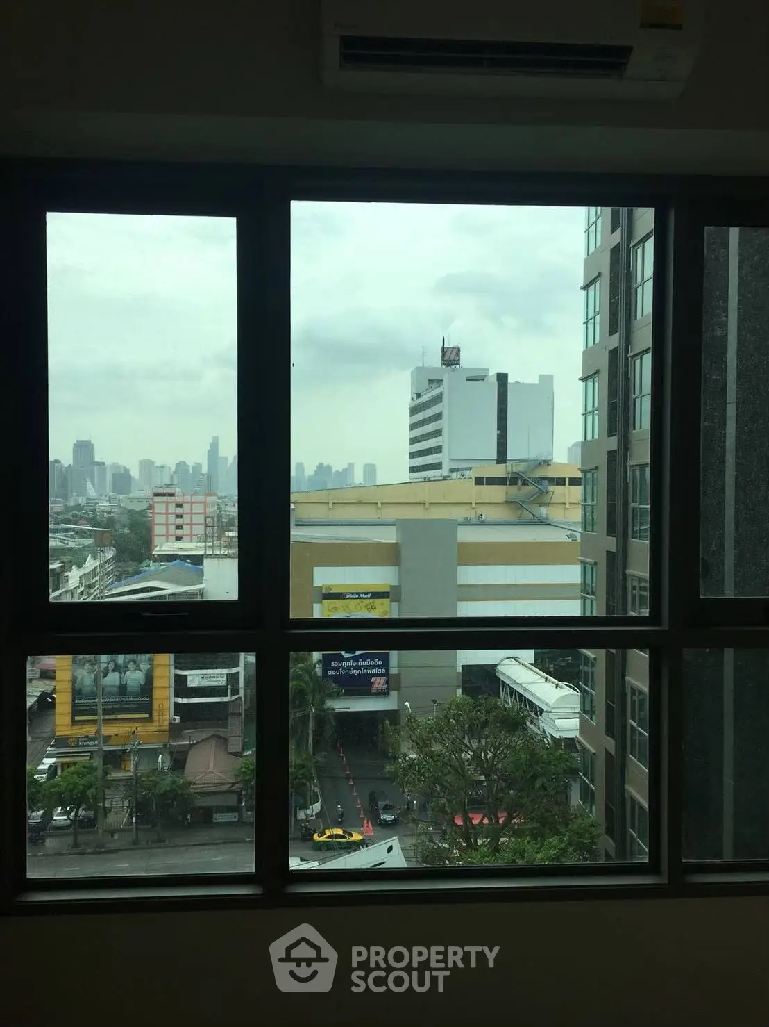 Cityscape view from a high-rise window showcasing urban skyline and buildings.