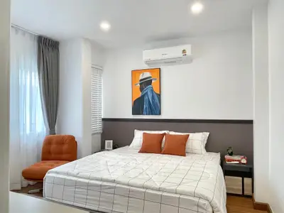 Modern bedroom with stylish decor and cozy ambiance, featuring a large bed and contemporary artwork.