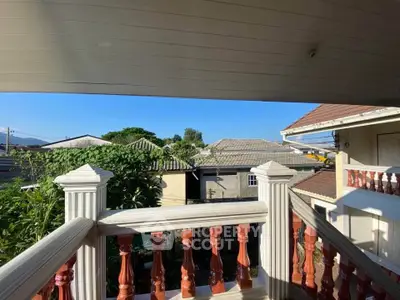 Charming balcony view with classic railing overlooking neighborhood rooftops.