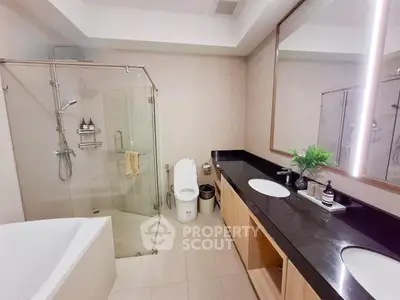 Luxurious modern bathroom with glass shower and sleek black countertop