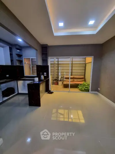 Modern open-plan living room with sleek kitchen and cozy balcony view