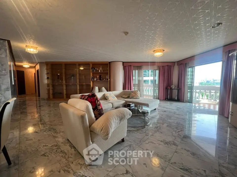 Spacious living room with marble floors and large windows offering city views.