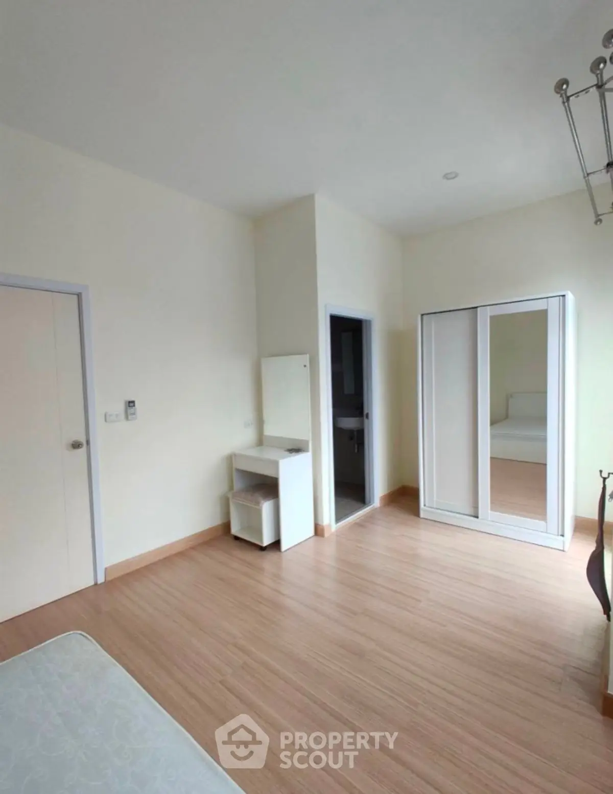 Spacious bedroom with modern wardrobe and vanity in minimalist style.