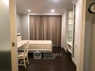 Elegant bedroom with dark wood flooring and built-in white cabinetry