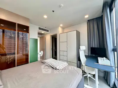 Modern bedroom with sleek furniture and large windows offering city views.