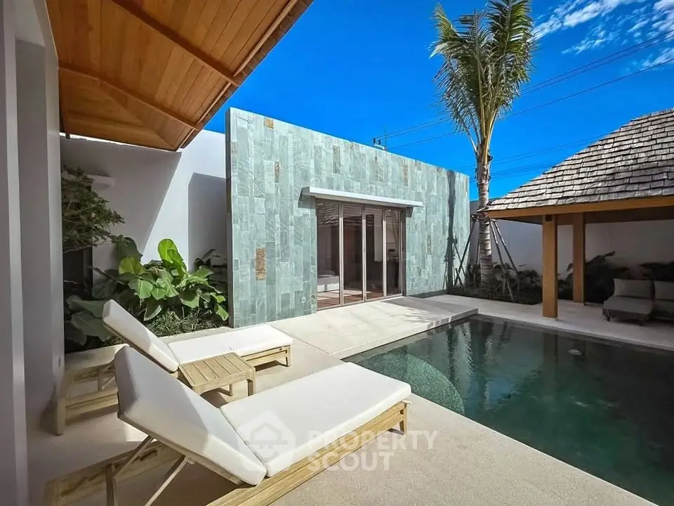 Luxurious private pool area with modern design and sun loungers in a tropical setting.
