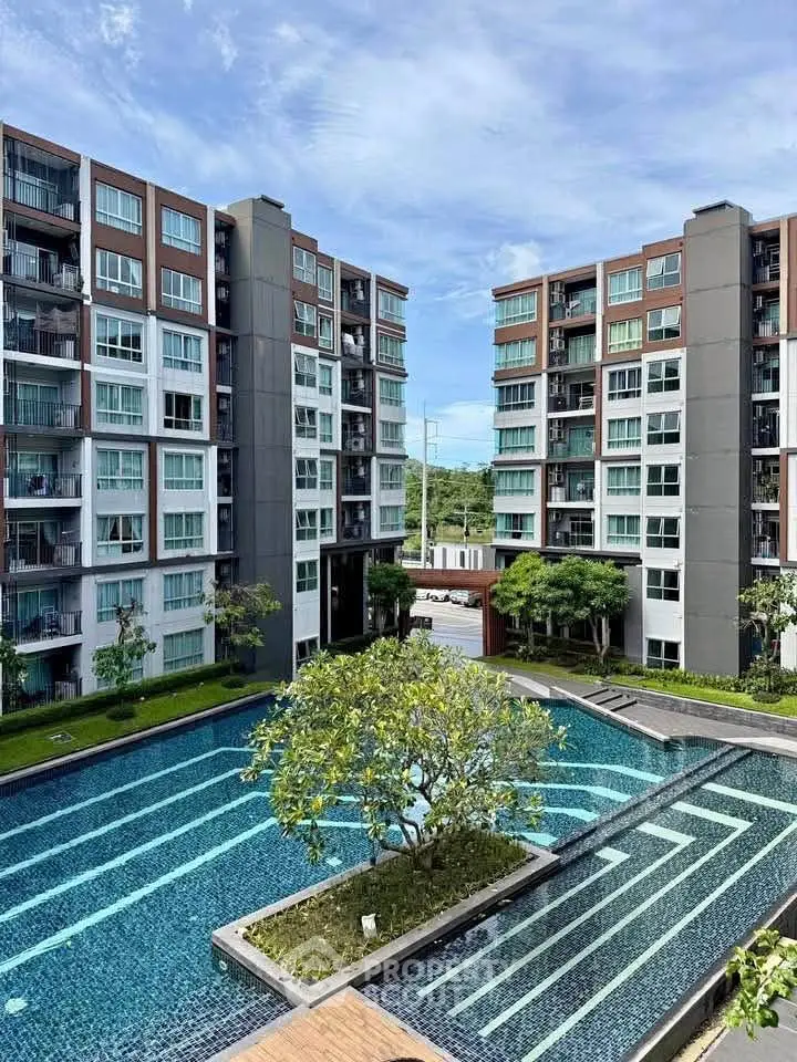 Modern apartment complex with pool and lush greenery
