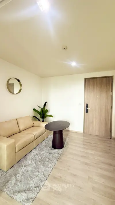 Modern living room with beige sofa, round mirror, and stylish decor