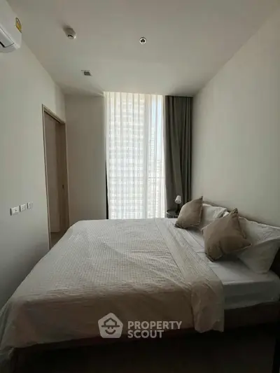 Cozy bedroom with natural light and modern decor in a stylish apartment.