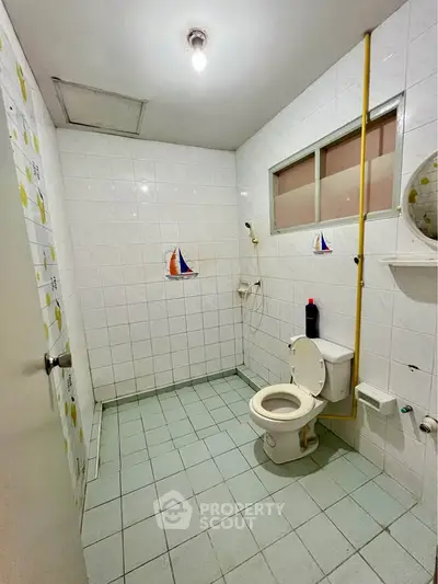 Spacious bathroom with nautical-themed tiles and modern fixtures.