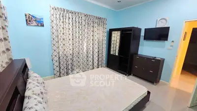 Spacious bedroom with modern furniture and wall-mounted TV in a cozy apartment.