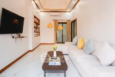 Modern living room with sleek design, large TV, and cozy seating area.