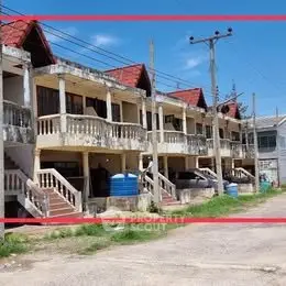 Charming row of townhouses with red roofs and spacious balconies, perfect for family living.