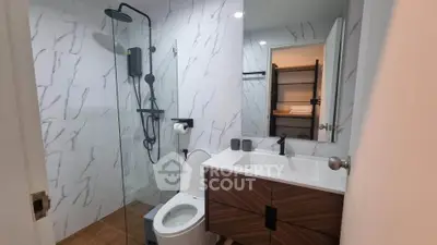 Modern bathroom with sleek shower and stylish vanity in contemporary home.