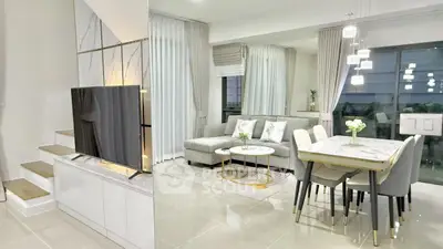 Modern living room with elegant decor and dining area, featuring a sleek TV setup and stylish furniture.