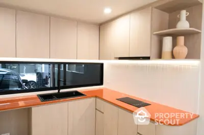 Modern kitchen with sleek cabinetry and vibrant orange countertop