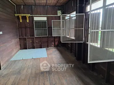 Charming rustic wooden interior with open windows and natural light, perfect for cozy living.
