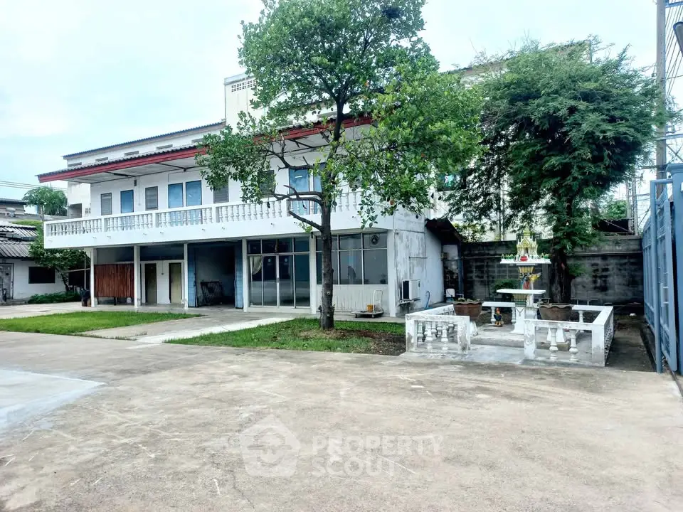 Spacious two-story house with large driveway and lush greenery, perfect for family living.