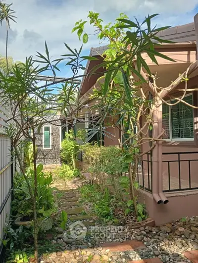 Charming garden pathway leading to a cozy home with lush greenery and natural stone accents.