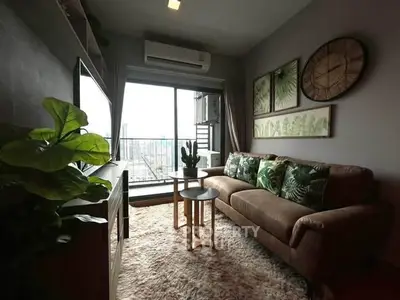 Stylish living room with cozy sofa and balcony view in modern apartment