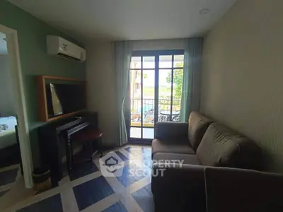 Cozy living room with modern decor and balcony view, perfect for relaxation.