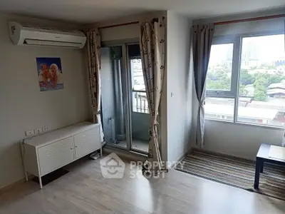 Bright living room with balcony access and air conditioning in modern apartment.