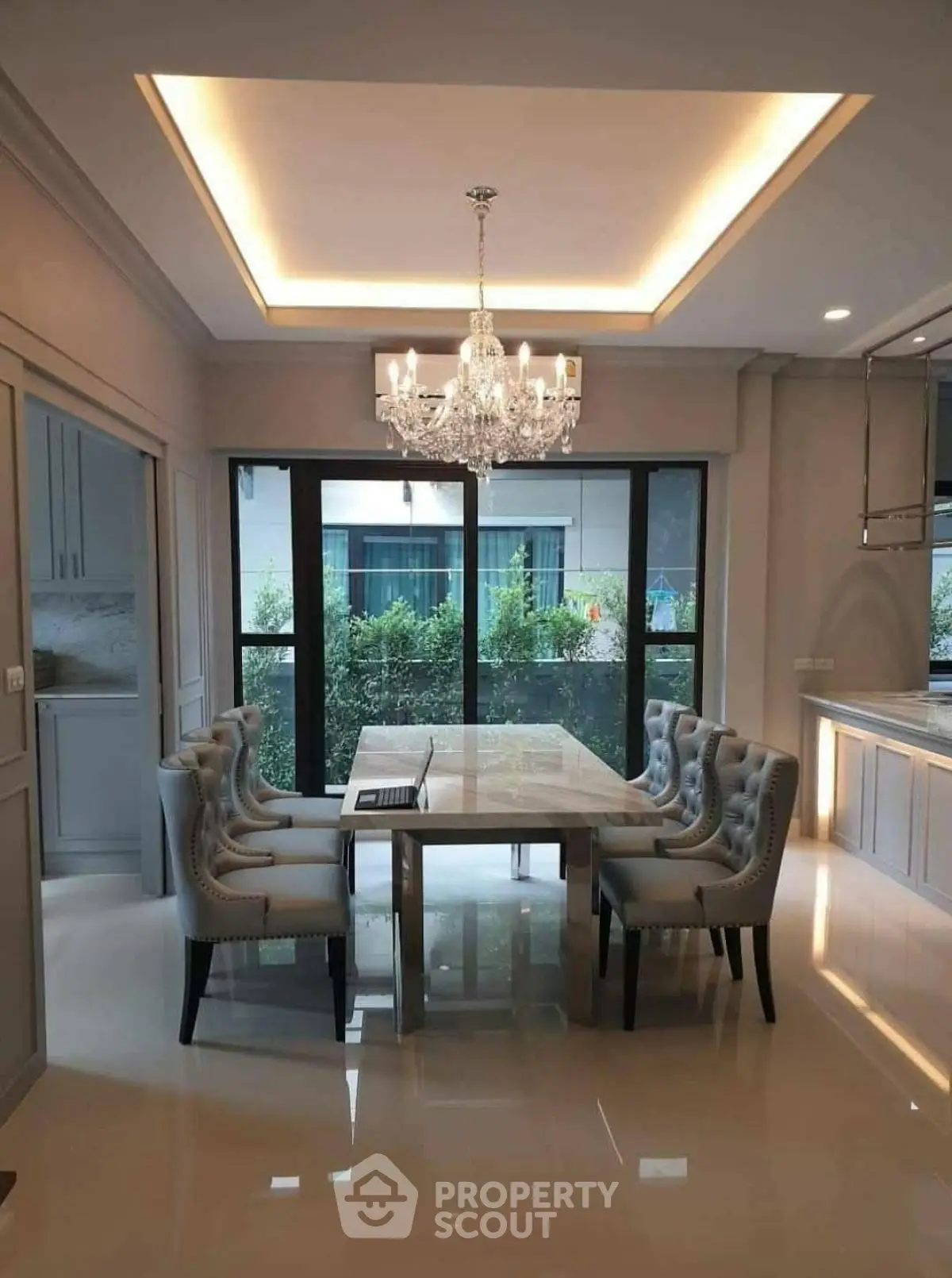 Elegant dining area with chandelier and garden view, perfect for family gatherings.