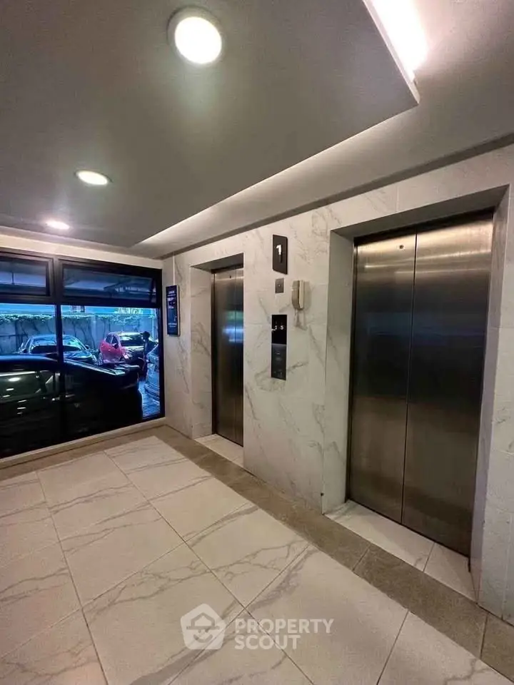 Modern building elevator lobby with sleek design and marble flooring.