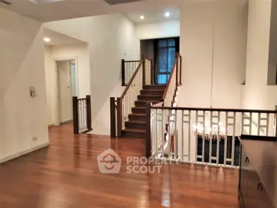 Elegant interior with wooden staircase and chandelier in spacious living area
