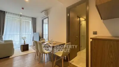 Modern open-plan living room with dining area and balcony access in a stylish apartment.