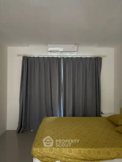 Cozy bedroom with air conditioning and elegant curtains, perfect for relaxation.