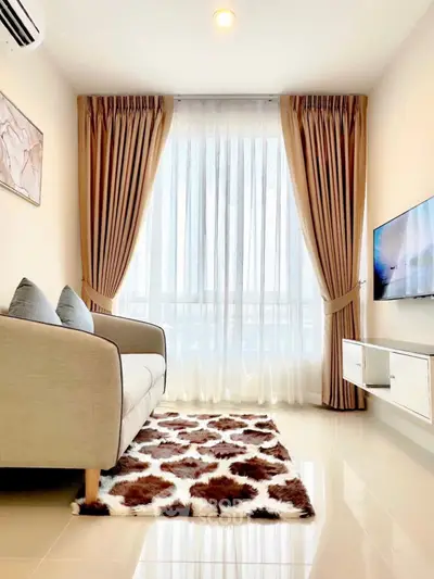 Elegant living room with plush sofa, stylish curtains, and mounted TV, perfect for modern comfort.