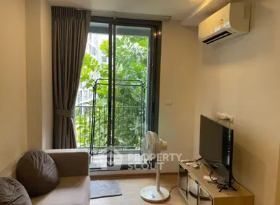 Cozy living room with balcony view, featuring modern furniture and air conditioning.