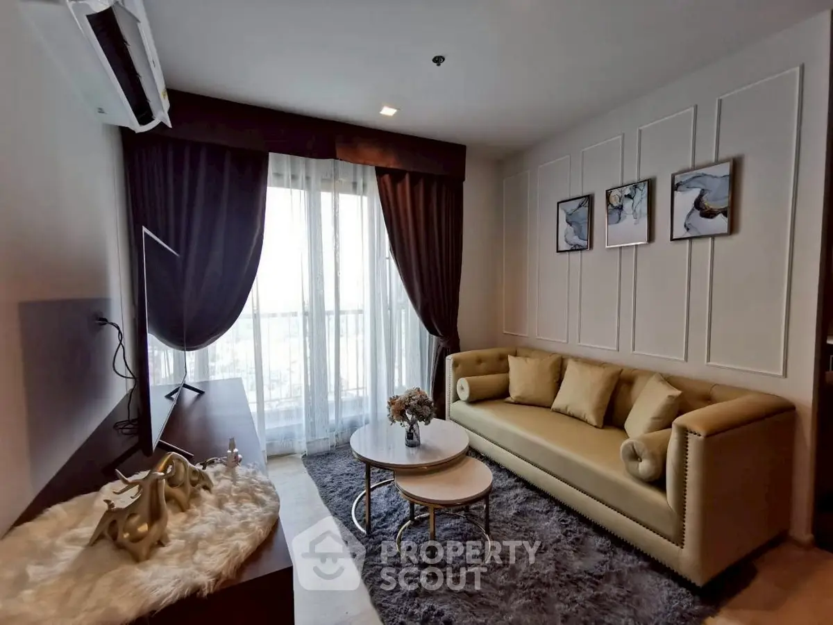 Elegant living room with plush sofa, modern decor, and large window offering natural light.