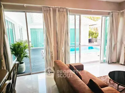 Luxurious living room with pool view and elegant decor, perfect for relaxation and entertaining.