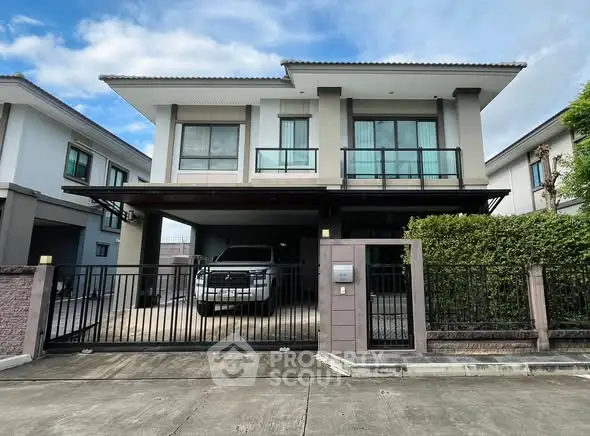 Modern two-story house with spacious driveway and sleek design.