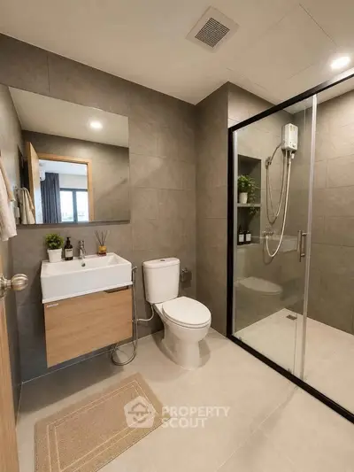 Modern bathroom with sleek design, glass shower, and stylish fixtures in a contemporary apartment.