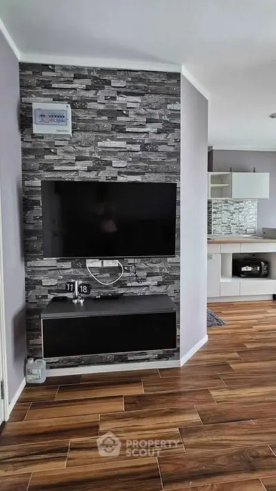 Modern living room with stylish stone accent wall and sleek wooden flooring