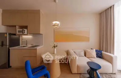 Modern living room with stylish furniture and open kitchen layout, featuring a cozy sofa and elegant decor.