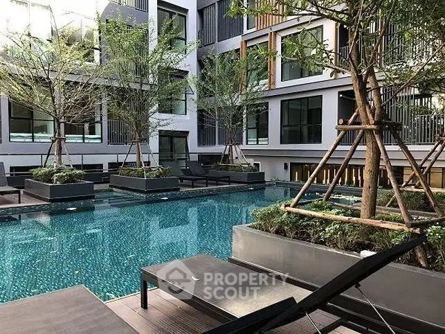 Luxurious apartment complex with modern pool and lush greenery