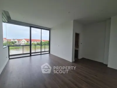 Spacious modern living room with large windows and stunning view of suburban houses.