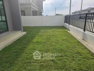 Spacious backyard with lush green lawn in modern residential area